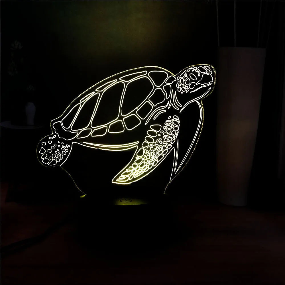 3D clear acrylic turtle-shaped LED night light with remote control on a desk.