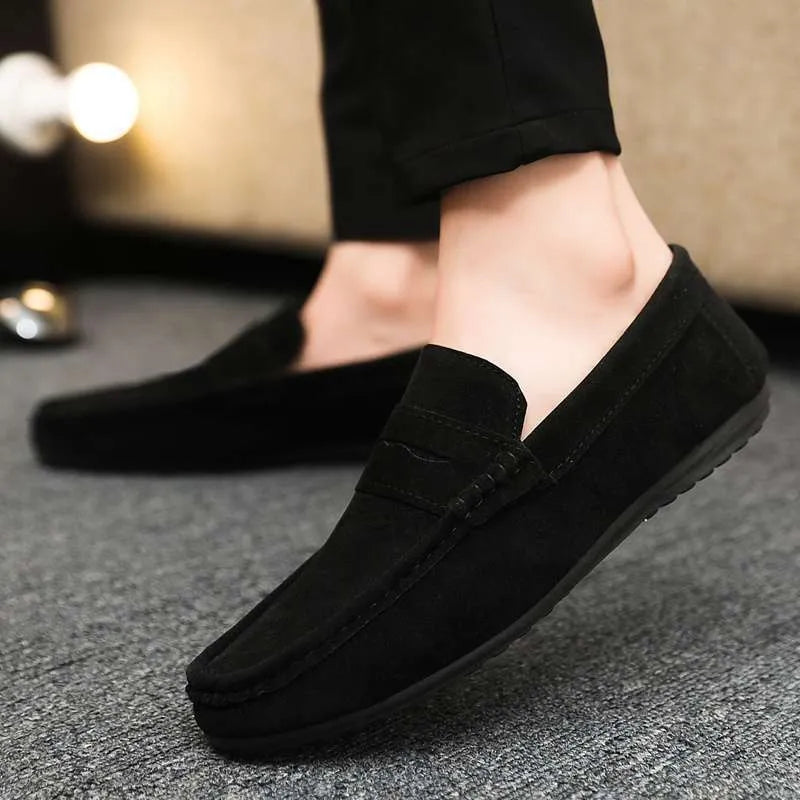 Men's black Gommino style slip-on loafers with round toe and textured rubber sole.