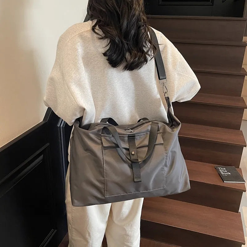 Grey one-shoulder Oxford cloth travel bag with 36-55L capacity and breathable lining