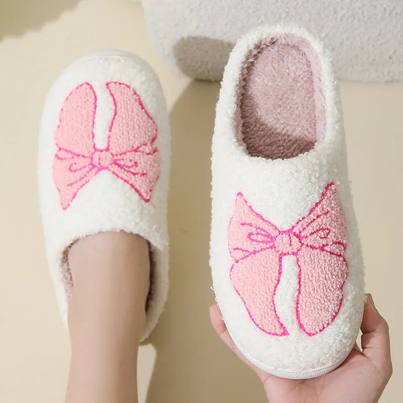 Cotton slippers with cartoon bow knot design on suede upper in pink or blue colours with TPR sole