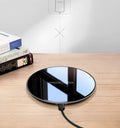 Black QI wireless charging pad with smooth plastic surface and silicone non-slip base
