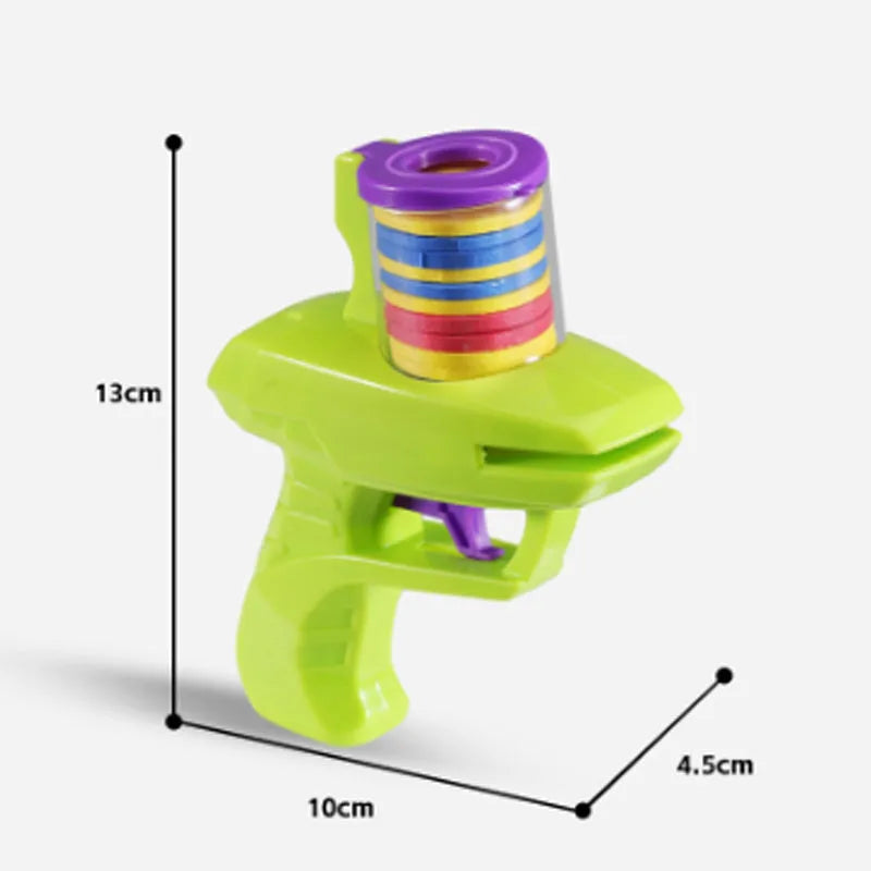 Green durable plastic manual cat toy launcher with a stack of soft foam discs on a floor.