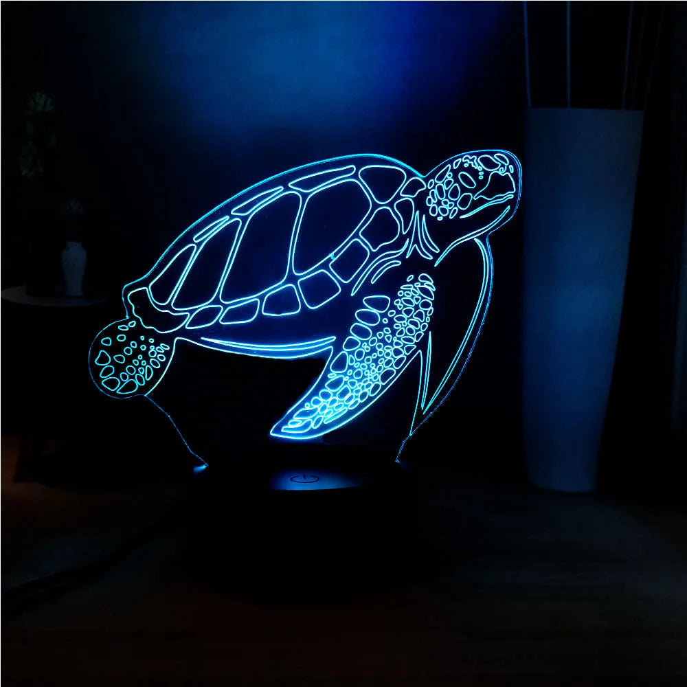 3D clear acrylic turtle-shaped LED night light with remote control on a desk.