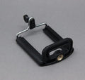 Black flexible octopus tripod with wrapped legs and spherical gimbal head for mounting a smartphone