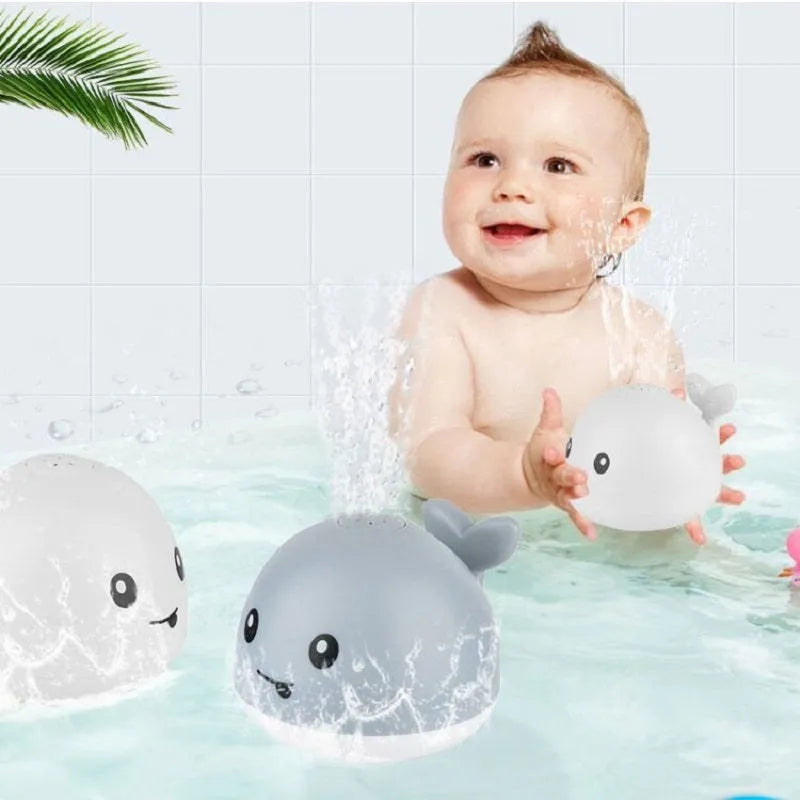 Automatic water spray whale bath toy with lights on a blue base.