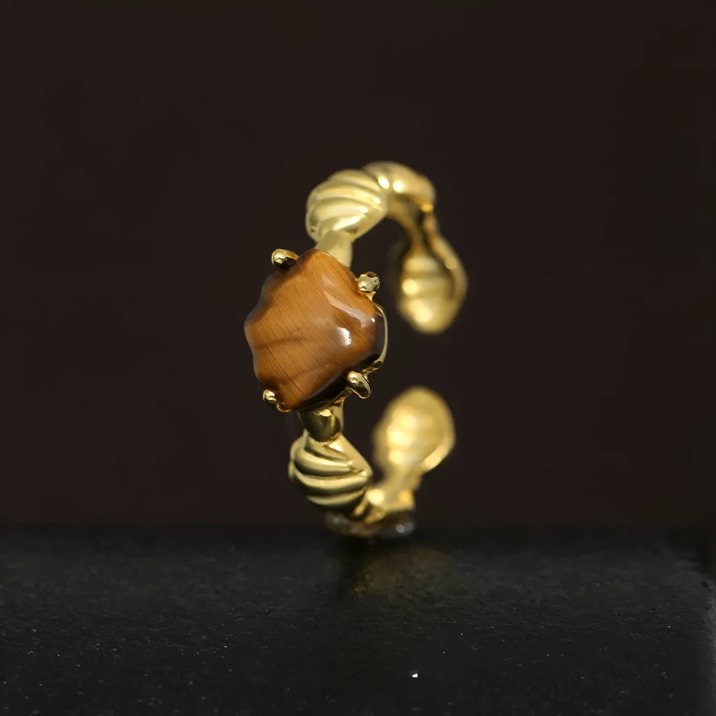 Adjustable silver ring with a shell design and tiger eye stone in white gold or gold finish.