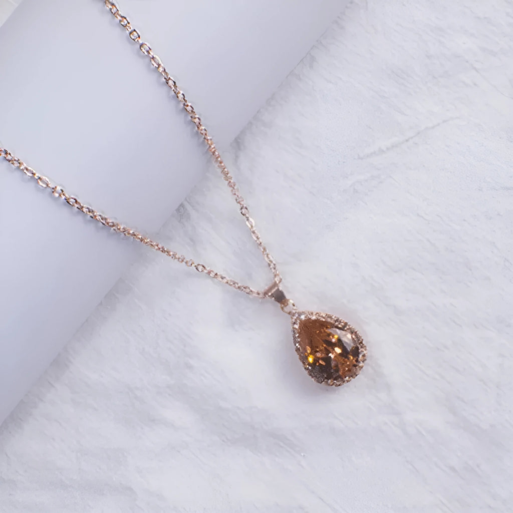 Women's pink alloy water drop necklace with geometric design and rose gold rhinestones on model