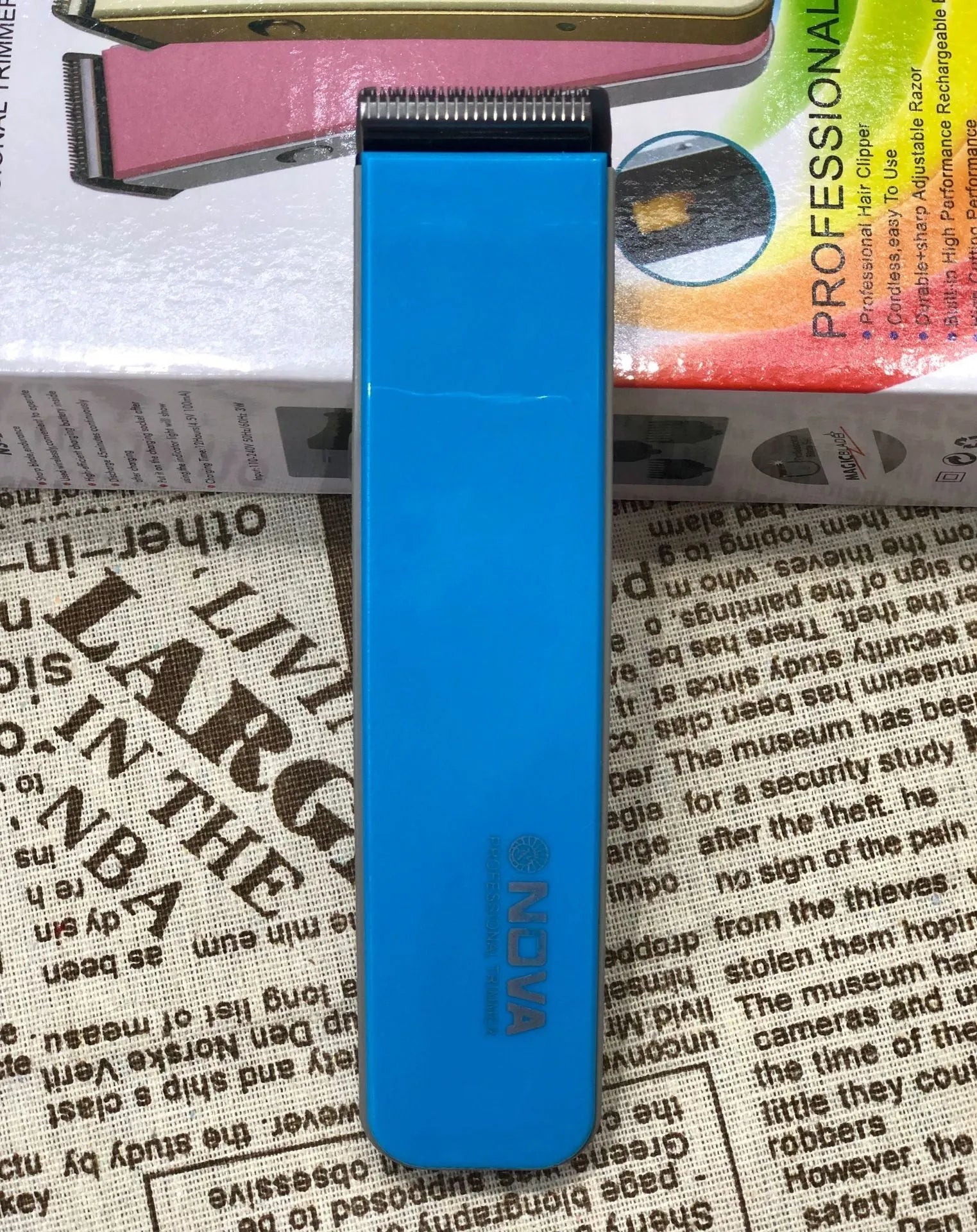 Electric hair clipper in multiple colours showing removable blade head and AA battery compartment.