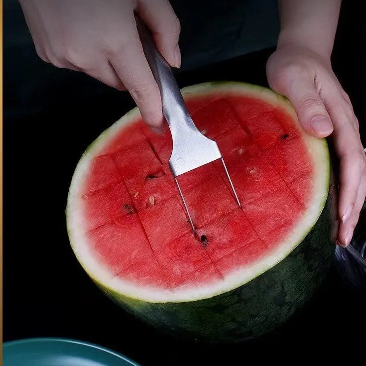 Silver stainless steel watermelon slicer with a 26cm handle and a 3.6cm wide rounded fork head.