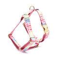 Pink dog harness with gold buckle and heart-shaped stone decoration on a chest and back strap
