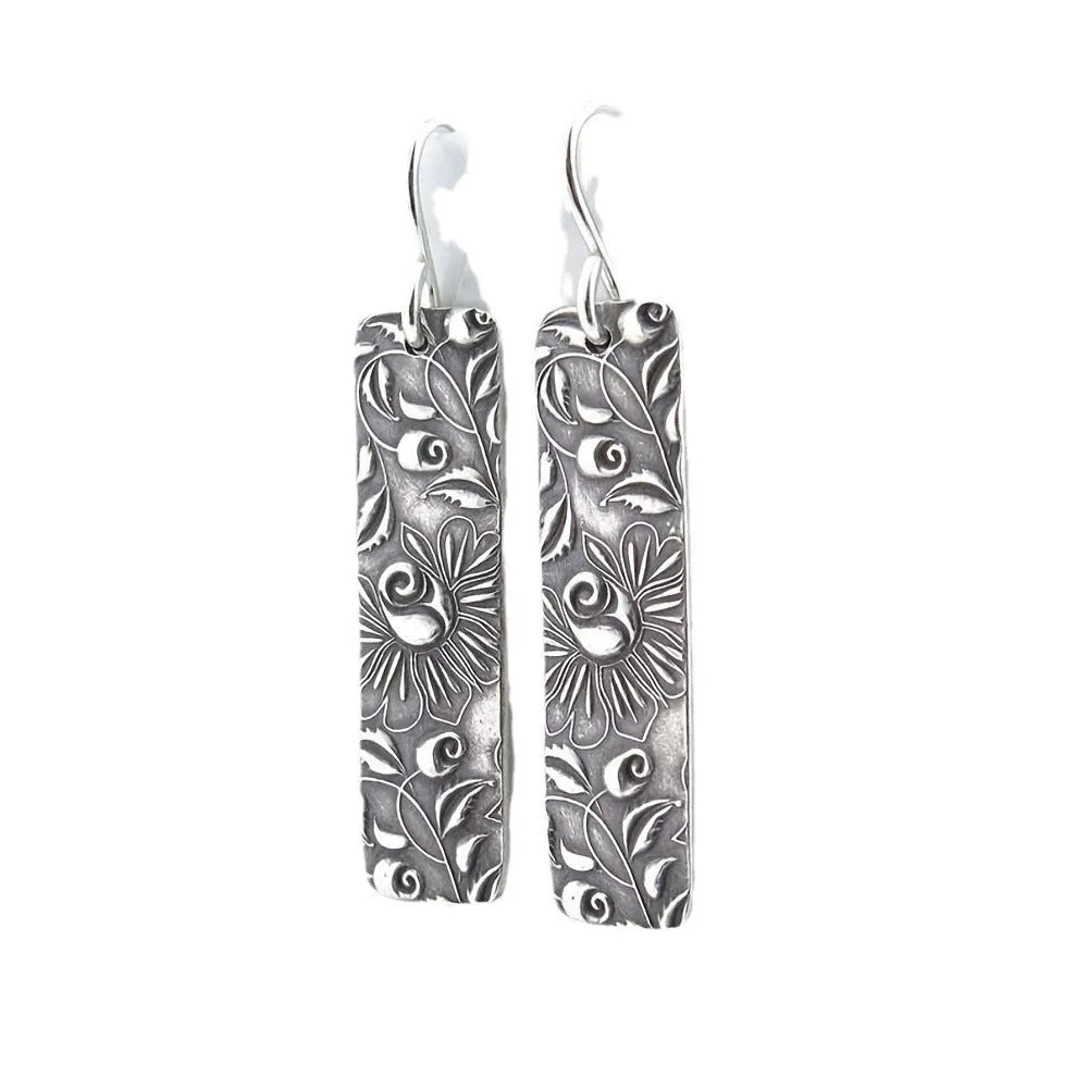 Silver-coloured long geometric drop earrings with carved vine patterns