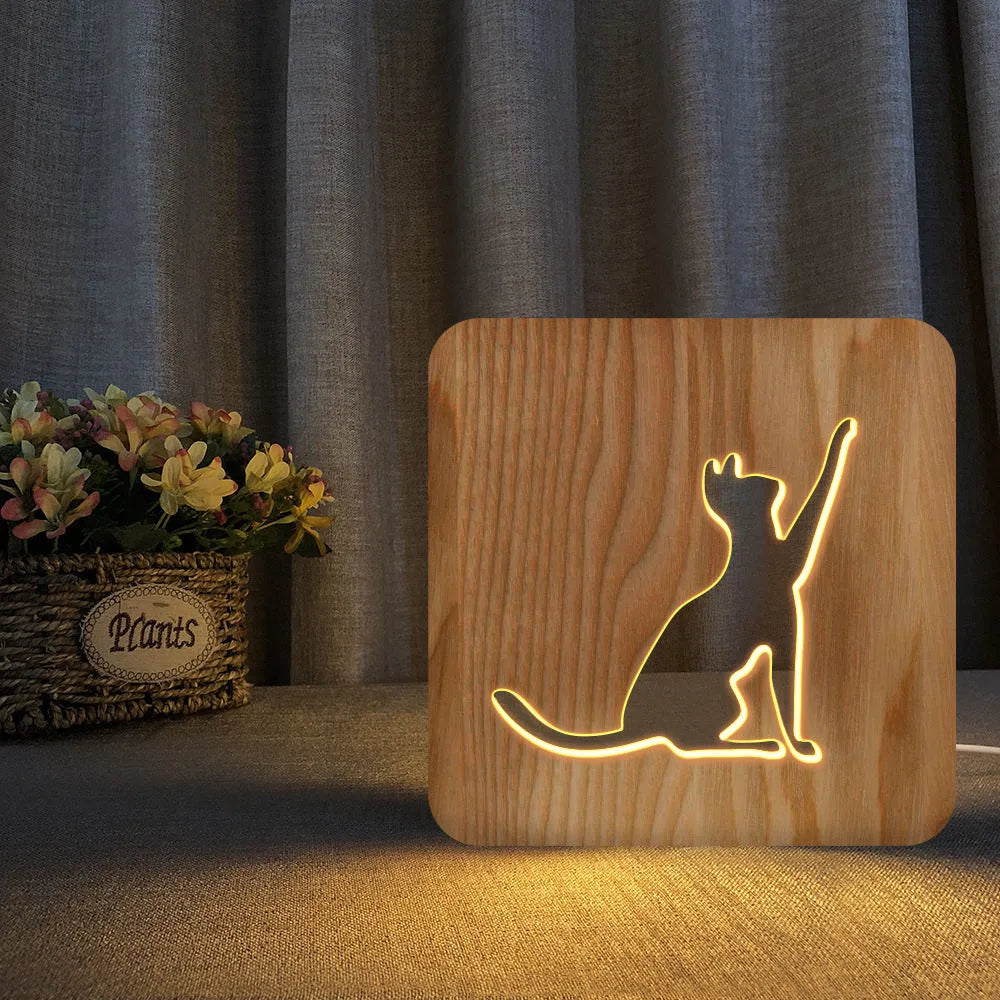 Solid wood 3D night light with hollow cat design on a table