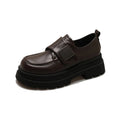 Women's black chunky heel shoes with square heel and cross strap on a plain background