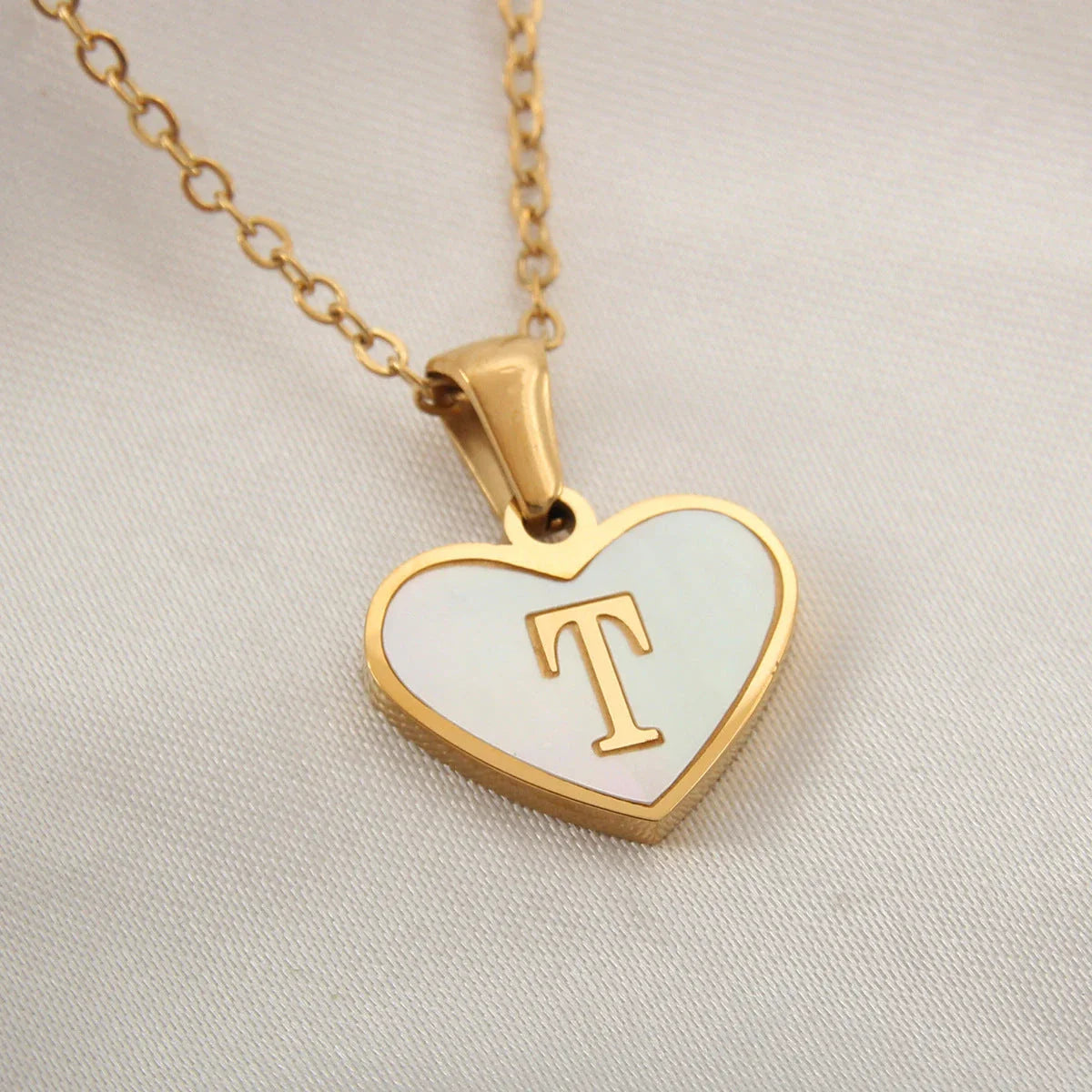 A personalized heart-shaped necklace with a 26-letter charm, crafted from high-quality stainless steel and gold plating.