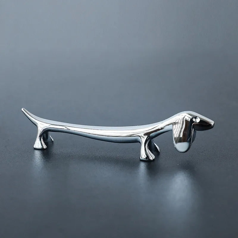 Silver zinc alloy sausage dog shaped chopstick rest on a table