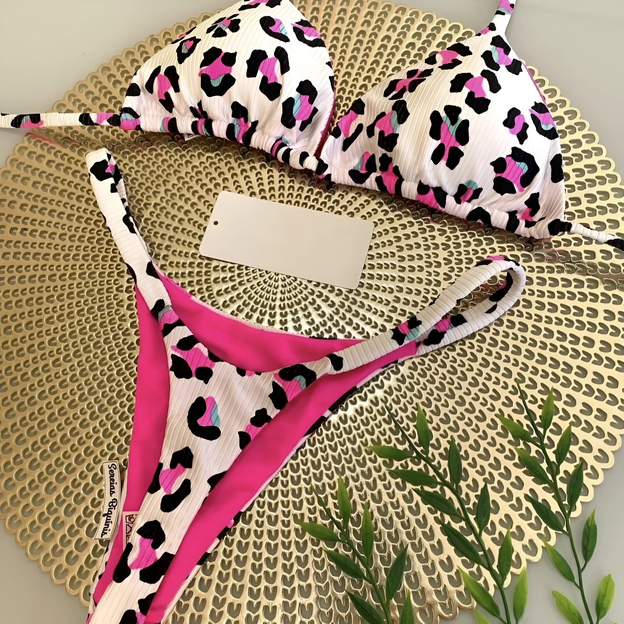 Women's printed bikini swimsuit on a hanger, showing briefs style with quick-drying fabric and cotton lining.