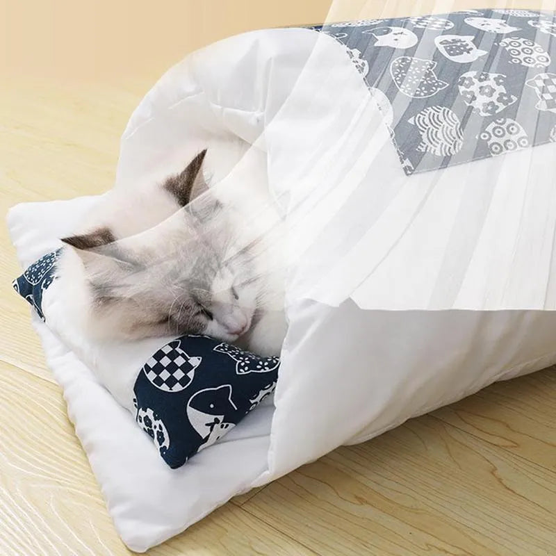 Grey covered cat sleeping bag bed with pillow, shown in medium size on a wooden floor.
