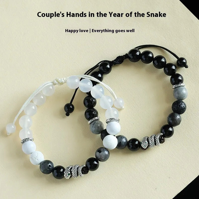 A matching couple bracelet set: one black agate and one white agate bracelet with snake chain clasps.