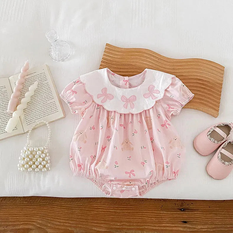 Pink cotton newborn triangle rompers with short sleeves and three bow details for summer outwear