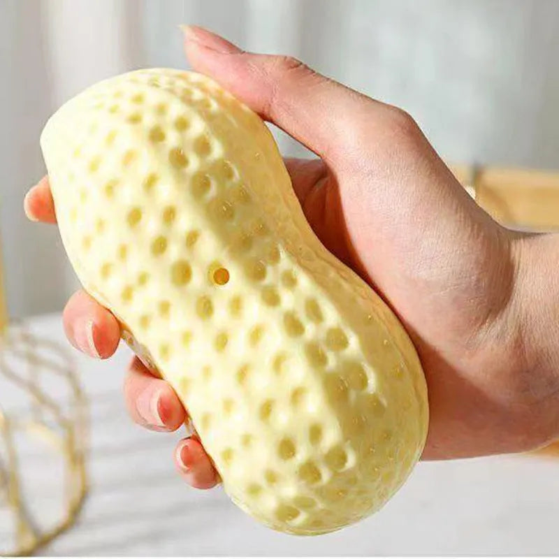 Yellow peanut-shaped dog chew toy with textured surface and squeaker for teeth cleaning and interactive play