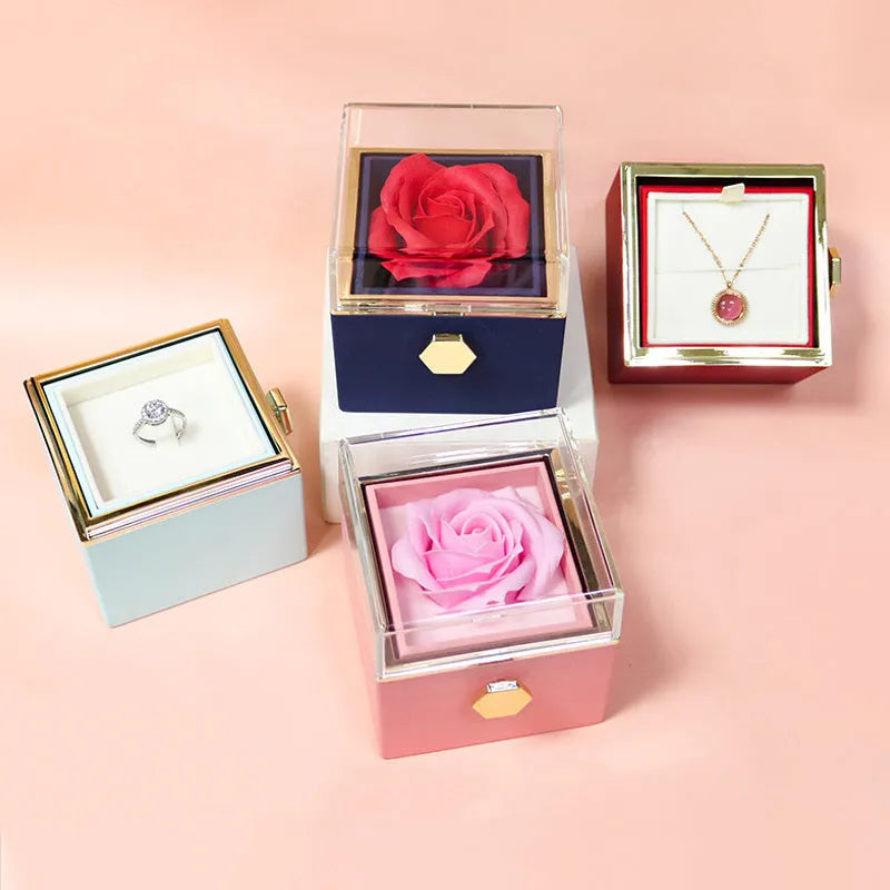 Rotating jewellery box with preserved red rose under acrylic cover and drawer open showing storage