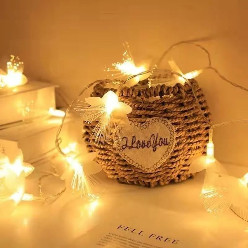 LED optical fibre flower light string with 20 warm white flower-shaped beads on a dark background