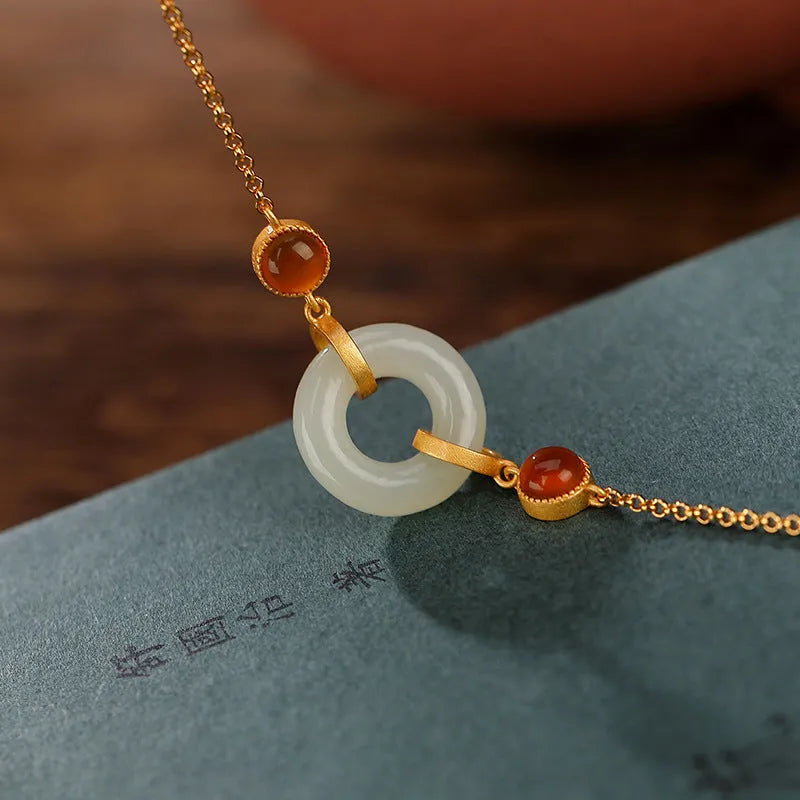 Close-up of a sterling silver bracelet with a gold-plated peace buckle holding inlaid natural Hetian jade.