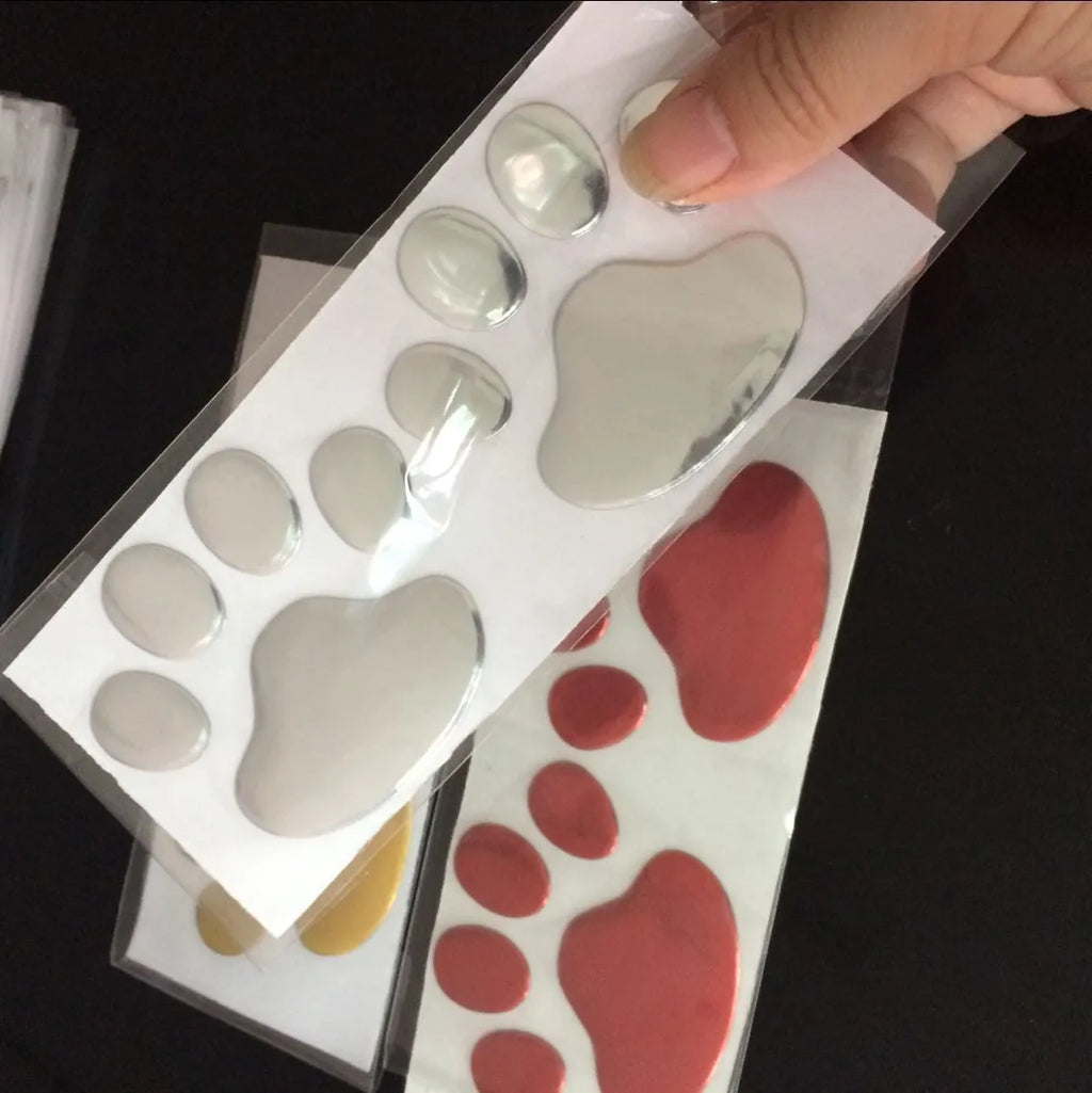 Hand-shaped brush car sticker with dog footprints design in red, silver, gold or black colour, 7 cm long.