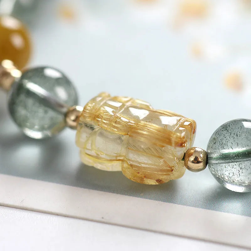 Green phantom quartz bracelet with gold rutile inclusions and geometric ethnic design