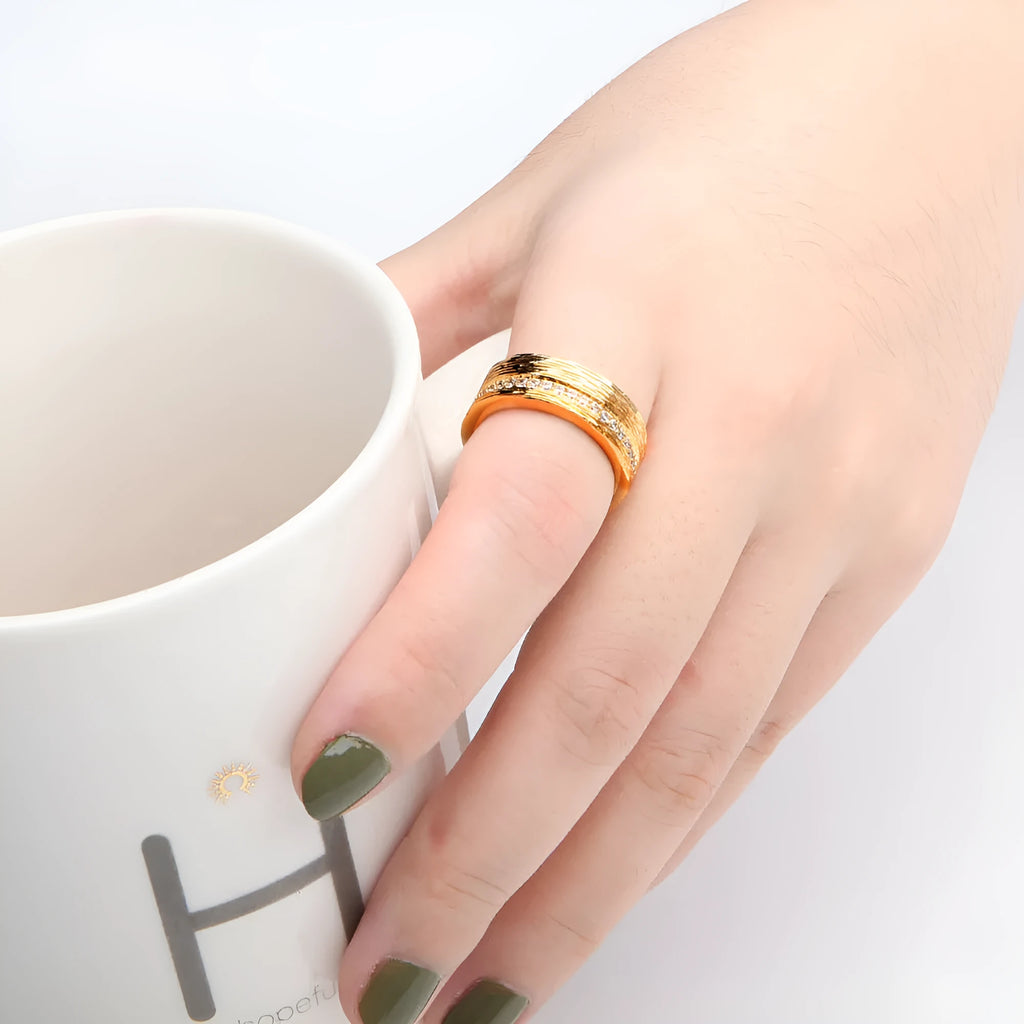 Gold coloured geometric zircon ring for women on a plain background.