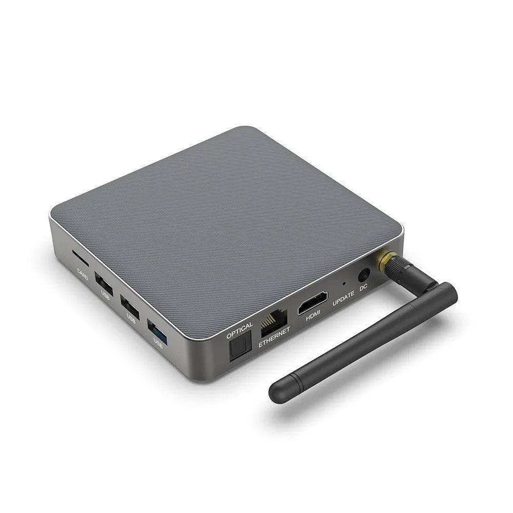 Black Android 8K network set-top box with remote, HDMI cable, and power supply on a wooden surface.