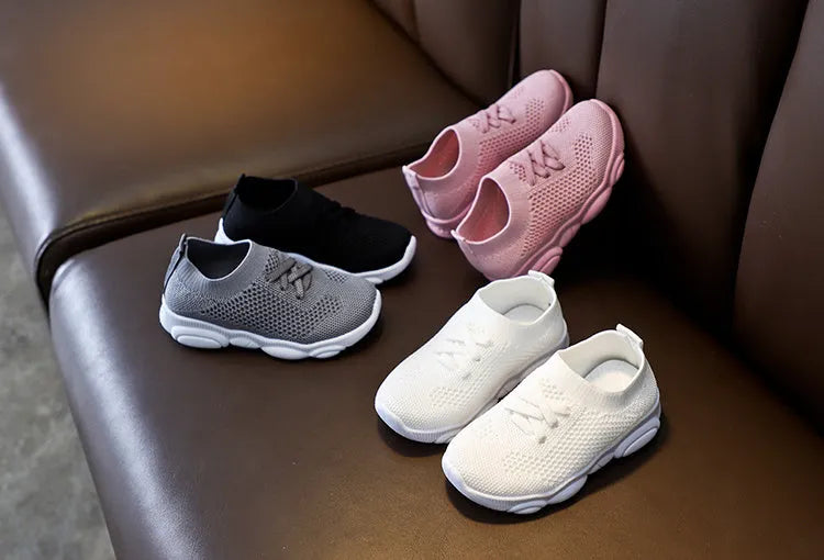 Children's white fabric lazy shoe with a non-slip rubber sole, shown on a foot.