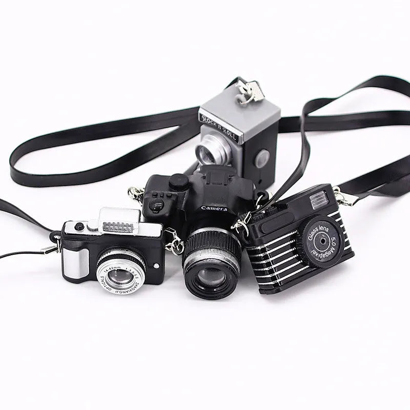 Plastic shrinking toy doll camera accessory with lanyard in digital style, packaged in net bag
