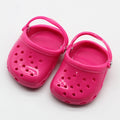 A pair of small plastic doll beach slippers in assorted colours: blue, red, yellow, and green.
