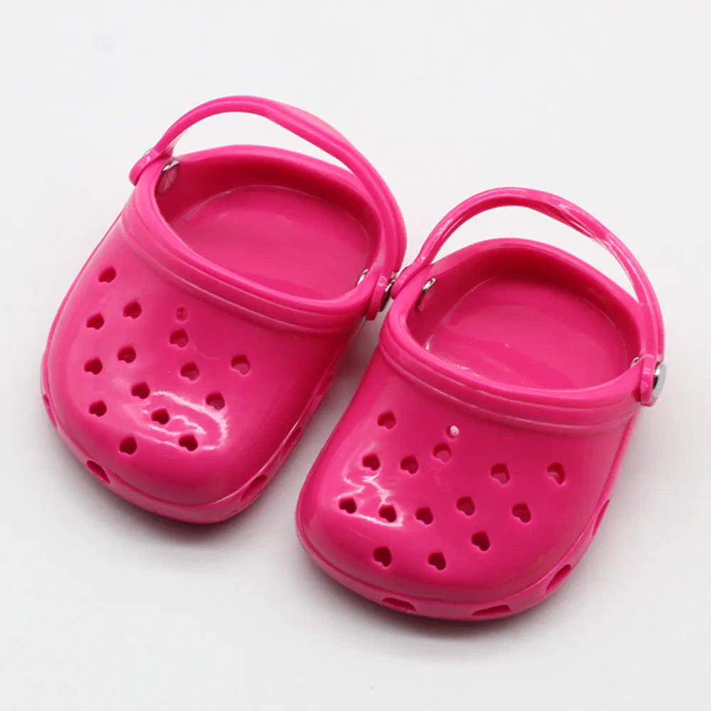 A pair of small plastic doll beach slippers in assorted colours: blue, red, yellow, and green.
