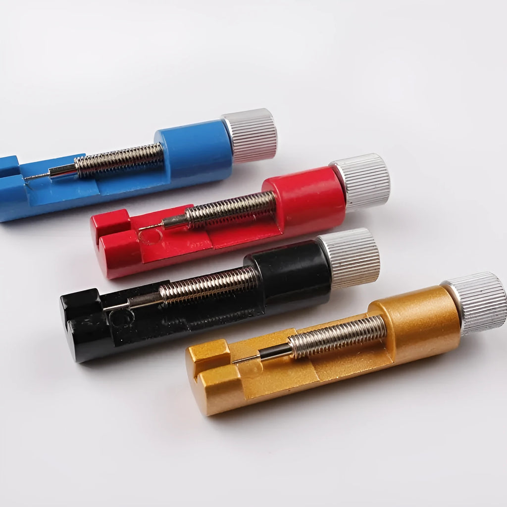 Gold metal watch link remover tool on white background, 6.4cm long, with three small thimbles