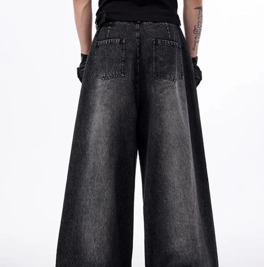 Black and grey washed denim wide leg trousers with structural zipper detail and matching vest, laid flat.