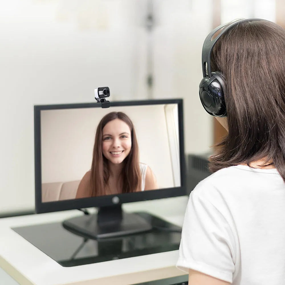 Blue mini USB webcam with rotating base on a laptop screen.