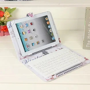 A black wireless Bluetooth keyboard next to its protective holster case, compatible with all phones and tablets.
