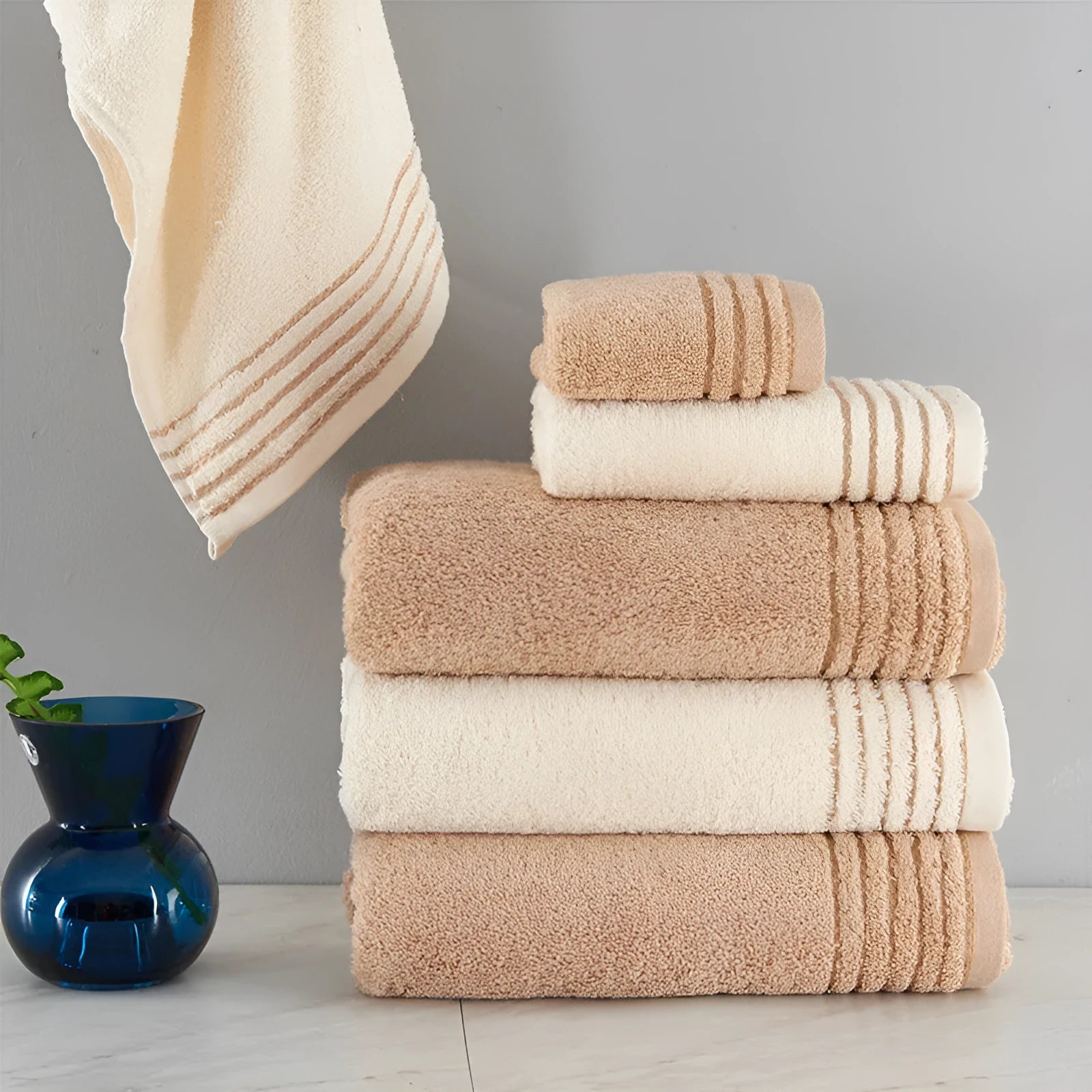 Cotton towel set in beige and brown showing face, hand, and bath towel sizes