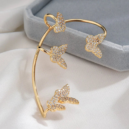 Sparkling zircon butterfly ear cuffs in gold-toned metal, featuring a delicate and elegant design for stylish accessorizing