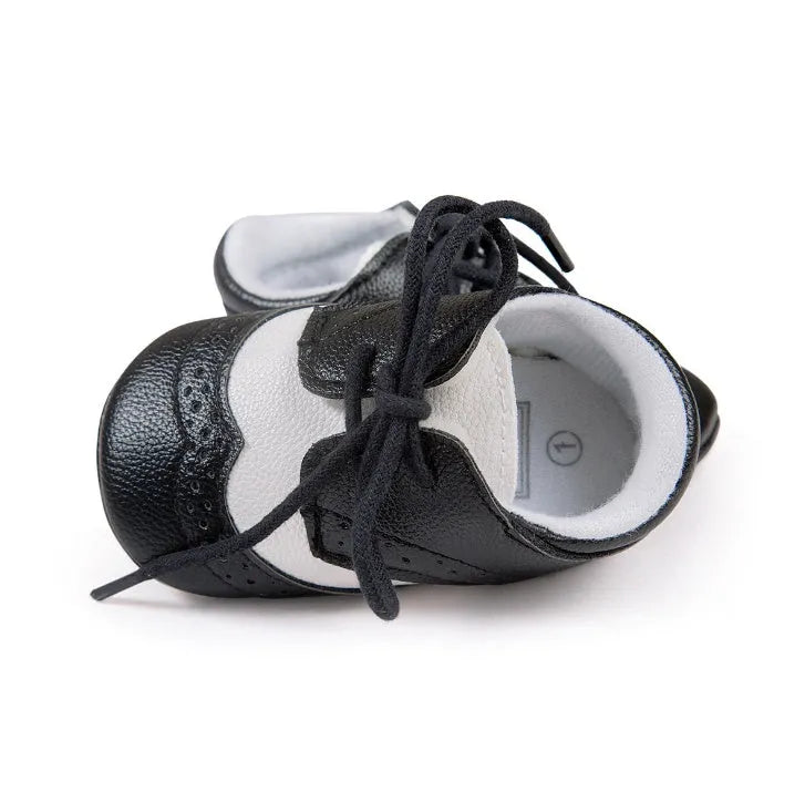 Vintage-style soft-soled baby shoes in synthetic leather, shown in light brown.