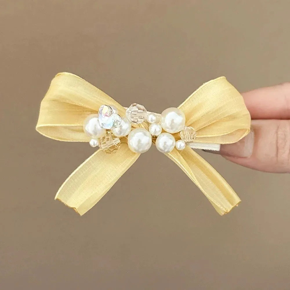Yellow cloth bow barrette with rhinestone and pearl accents on duckbill hair clip