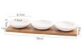 White porcelain multi-compartment dried fruit dish on a wooden serving board