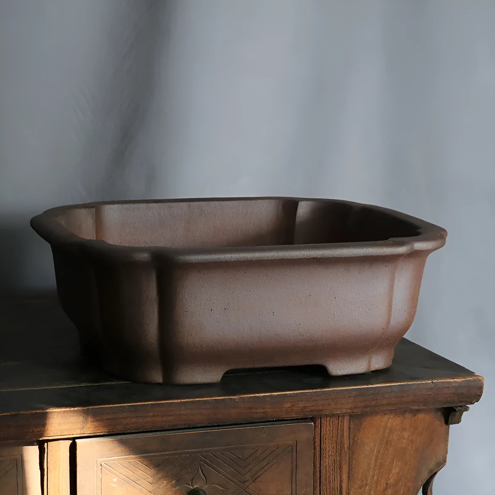 Rectangular purple sand bonsai flower pot with straight sides on a floor.
