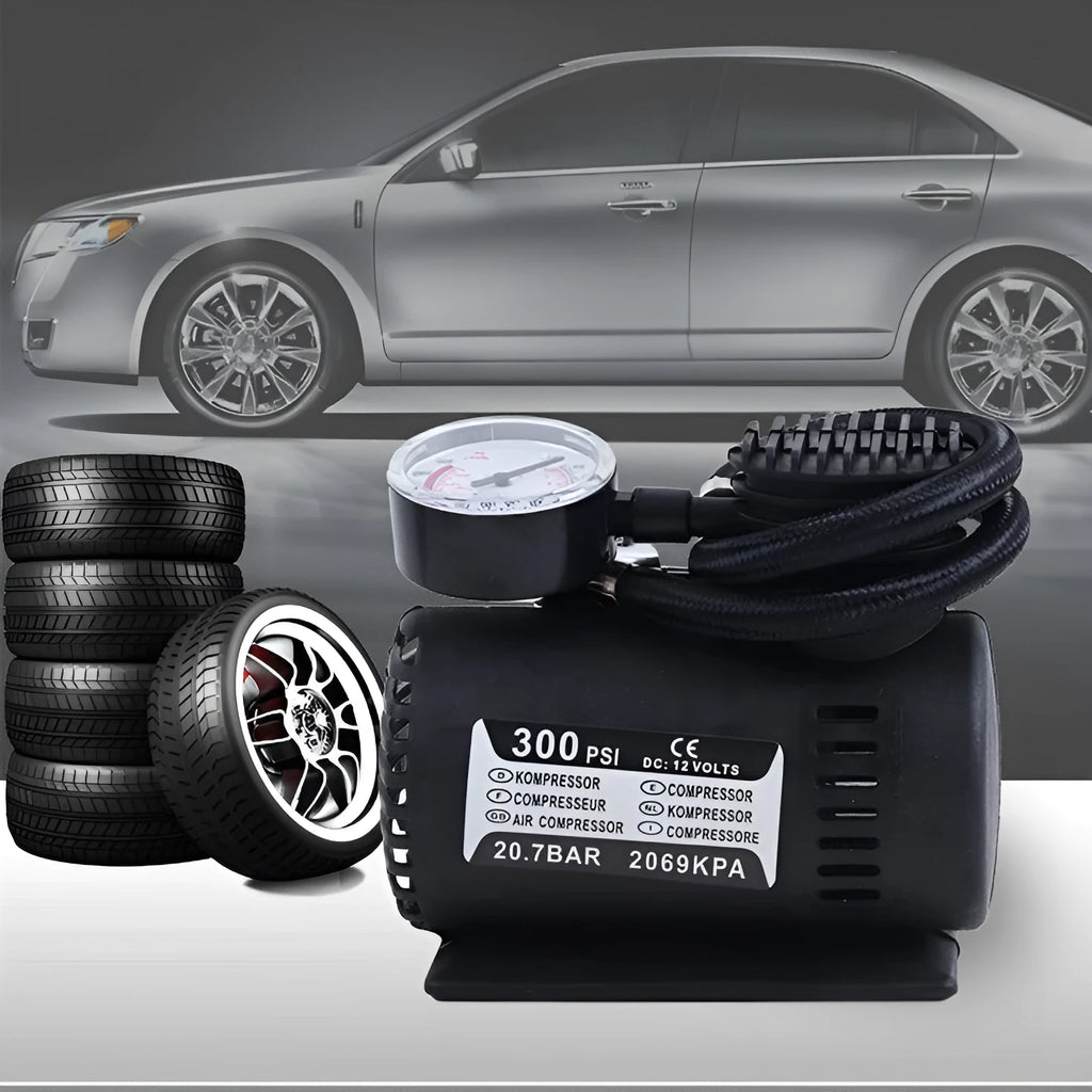 Black portable 12V mini car air compressor with pressure gauge, hose, and two nozzle adapters on grey background
