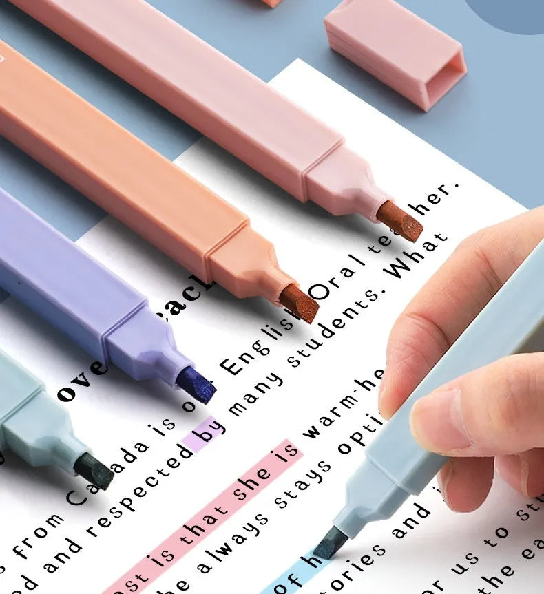 Set of double-ended fluorescent highlighting pens in mixed colours on a white surface.