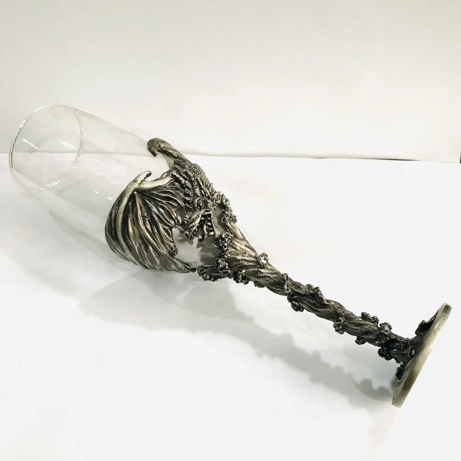 Alloy dinosaur champagne glass goblet in ancient tin colour on a surface, 21cm tall, retro style