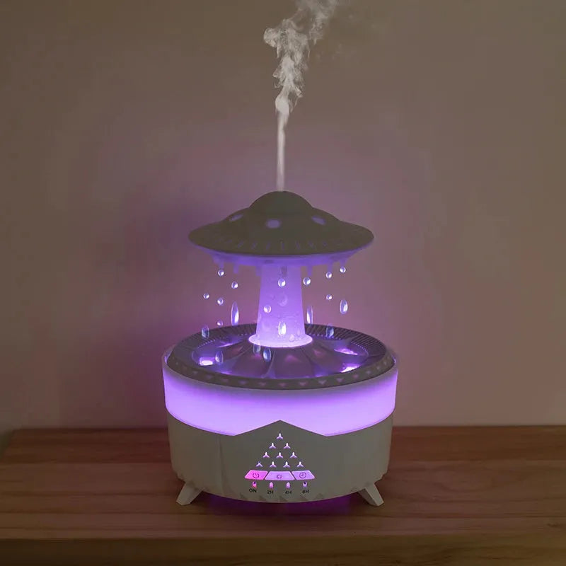 White cloud-shaped UFO raindrop humidifier diffuser with coloured night light on a wooden table.