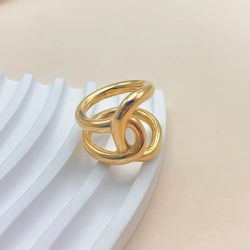 Women's stainless steel adjustable knot ring in geometric U-shape, shown in gold and steel colour finishes.